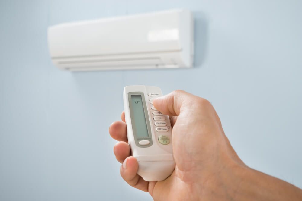 Man Adjusting Temperature of Air Conditioner — HVAC Systems in Bathurst, NSW