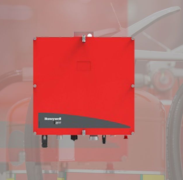 Red wall-mounted industrial control box with a small display and black base in a workshop setting
