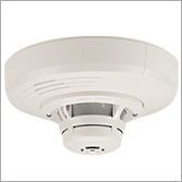 White wall-mounted alarm with yellow center beacon and red “ALERT” text on both sides