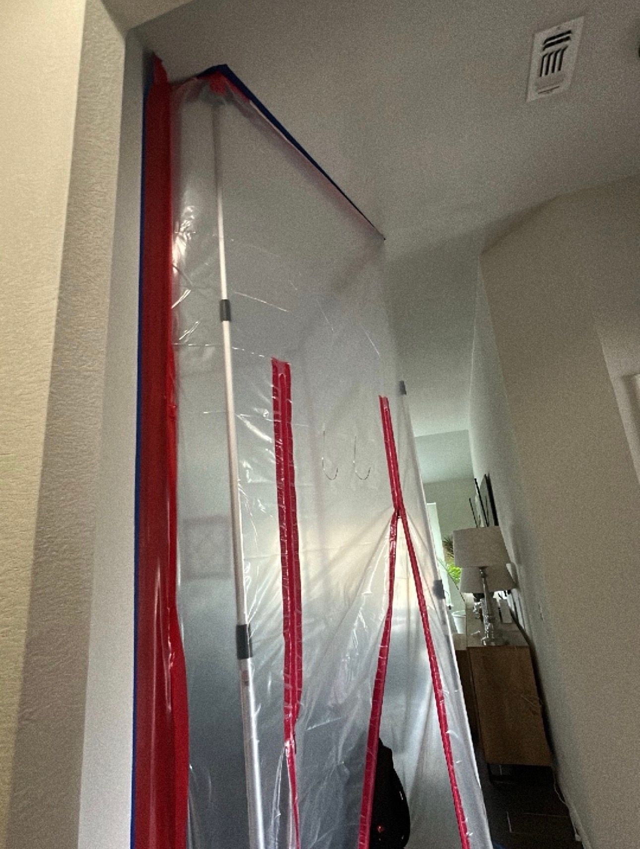 Plastic sheeting taped over a doorway in a hallway during renovation