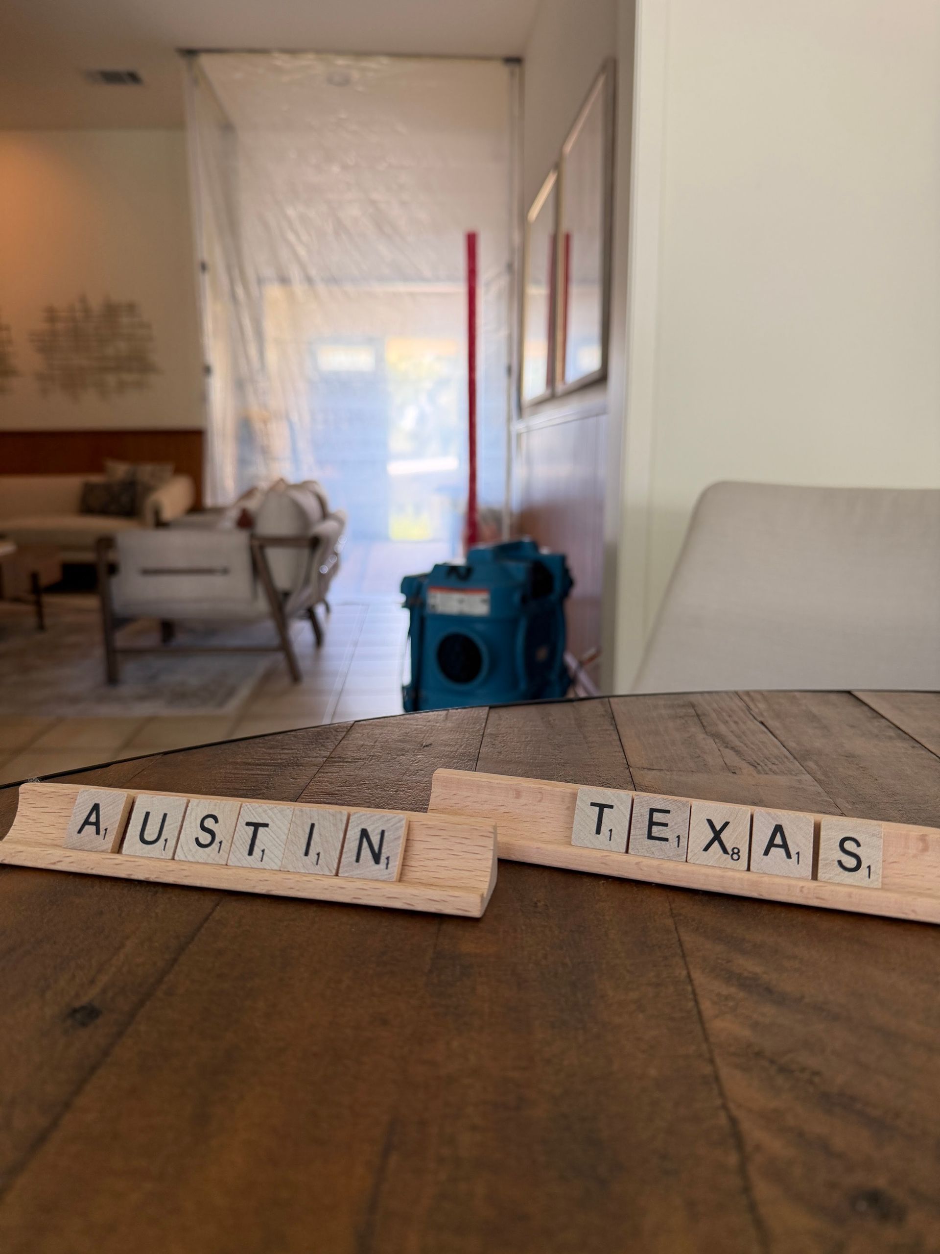 Wooden table with letter tiles spelling “Austin, Texas” in a bright living room