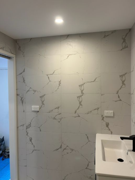 Bathroom Wall With White Marble-patterned Tiles — Fry Electrical In Lake Macquarie, NSW
