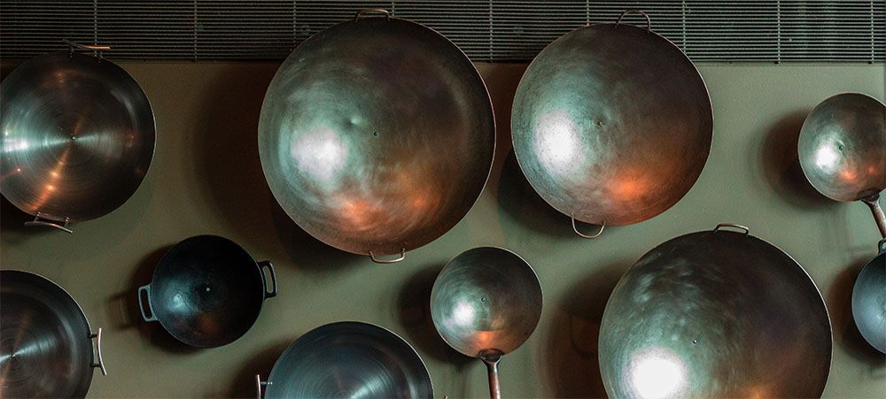A group of pots and pans hanging on a wall.