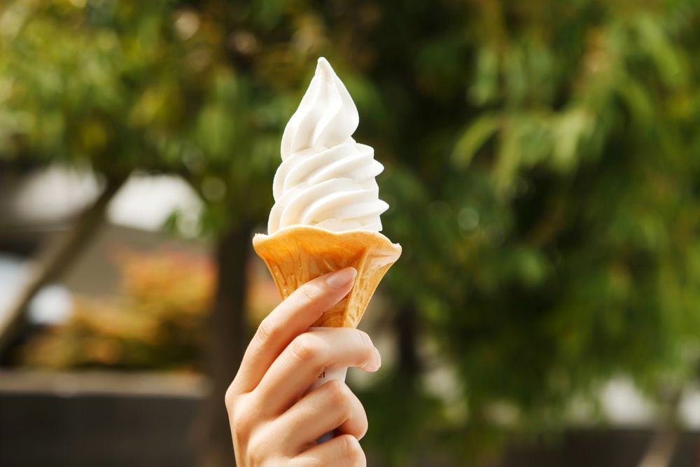A Person is Holding a Pink and White Ice Cream Cone — Frosty Whip in Rasmussen, QLD