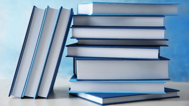 A stack of books with blue covers on a table