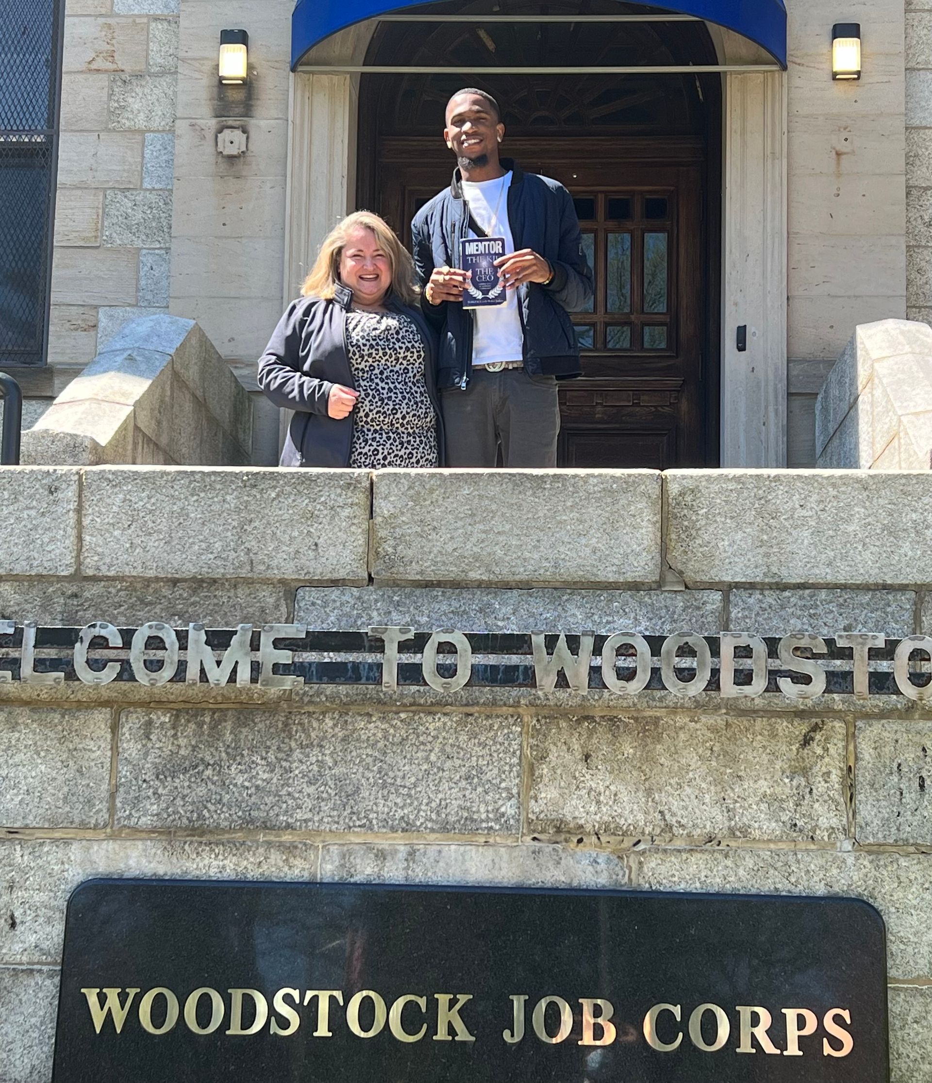 Two people standing in front of a woodstock job corps sign