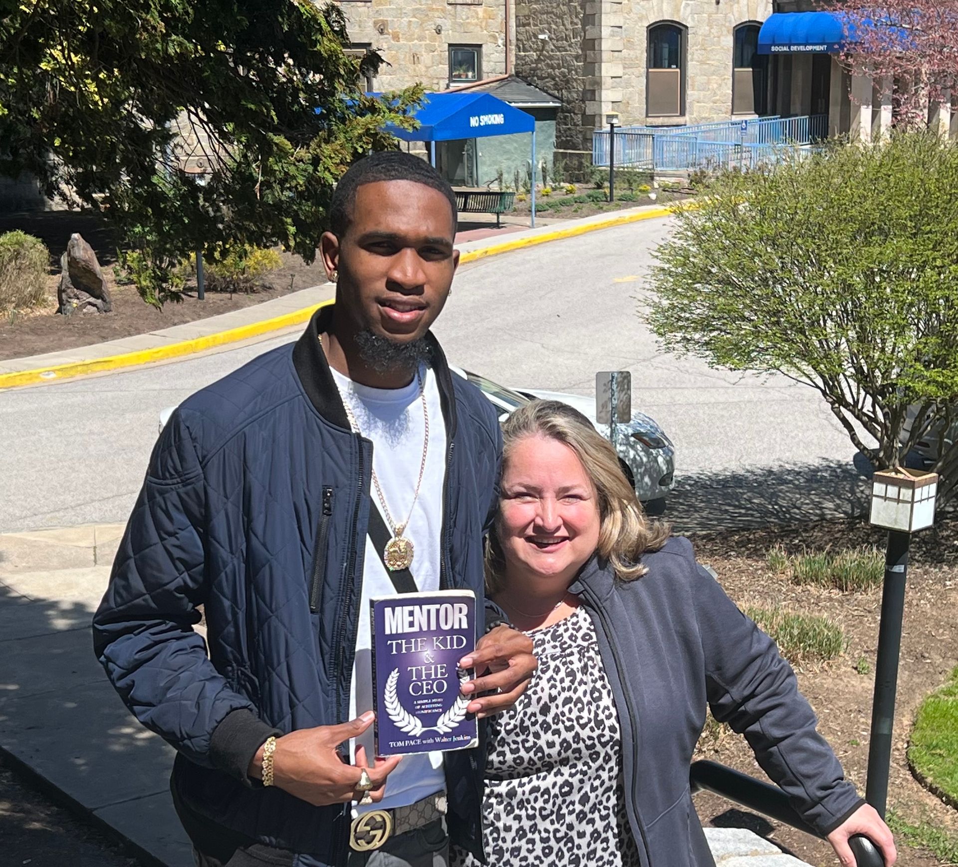 A man and a woman are standing next to each other holding a book.