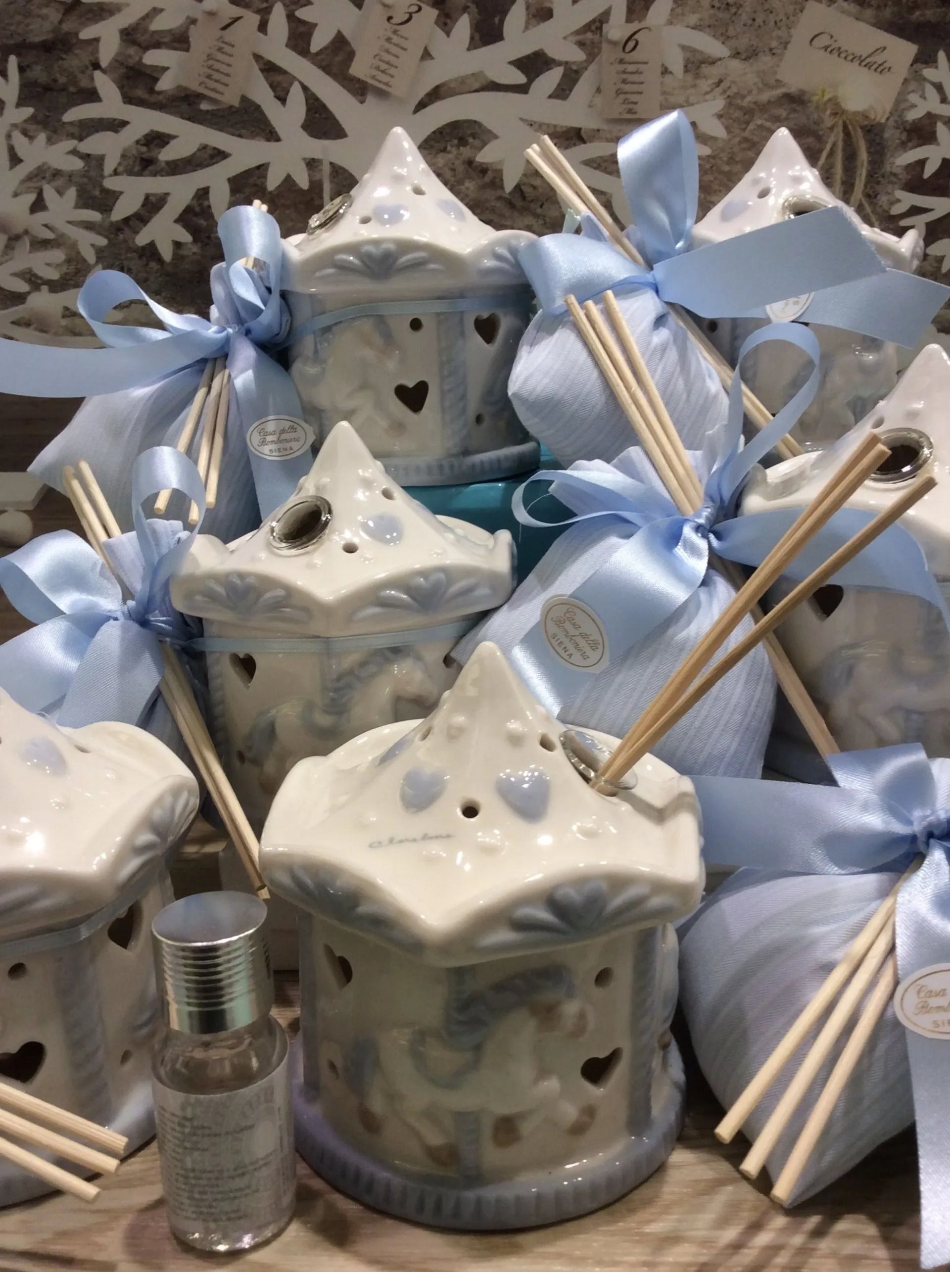 Vasi regalo blu e bianchi con nastri e diffusori a bastoncini disposti in un'esposizione decorativa