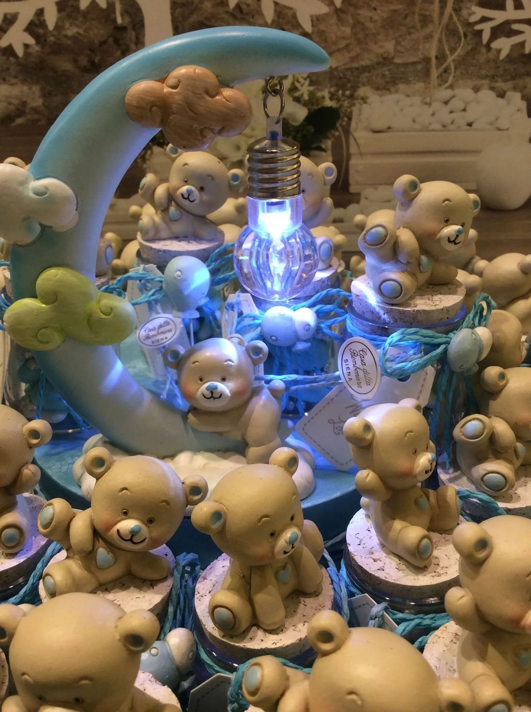 Orsacchiotti e animali di peluche attorno a una fontana blu luminosa al centro della scena.