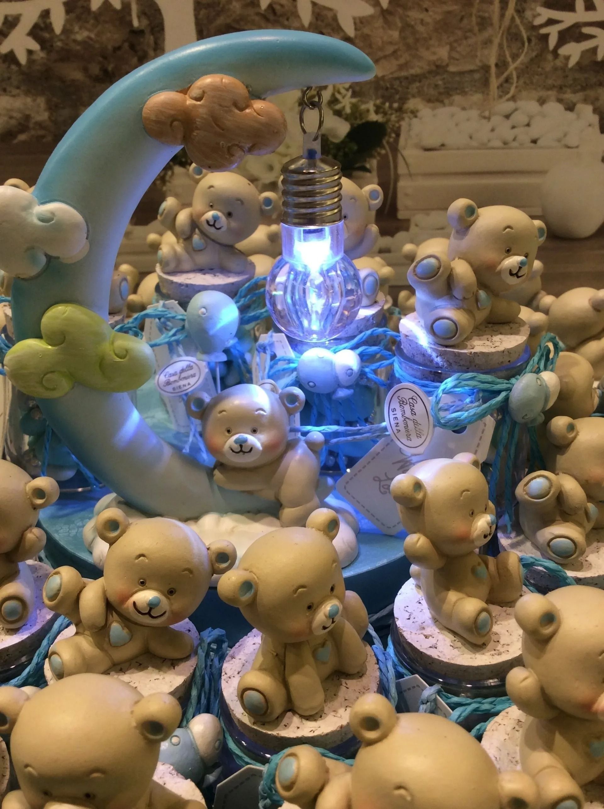 Orsacchiotti e animali di peluche attorno a una fontana blu luminosa al centro della scena.