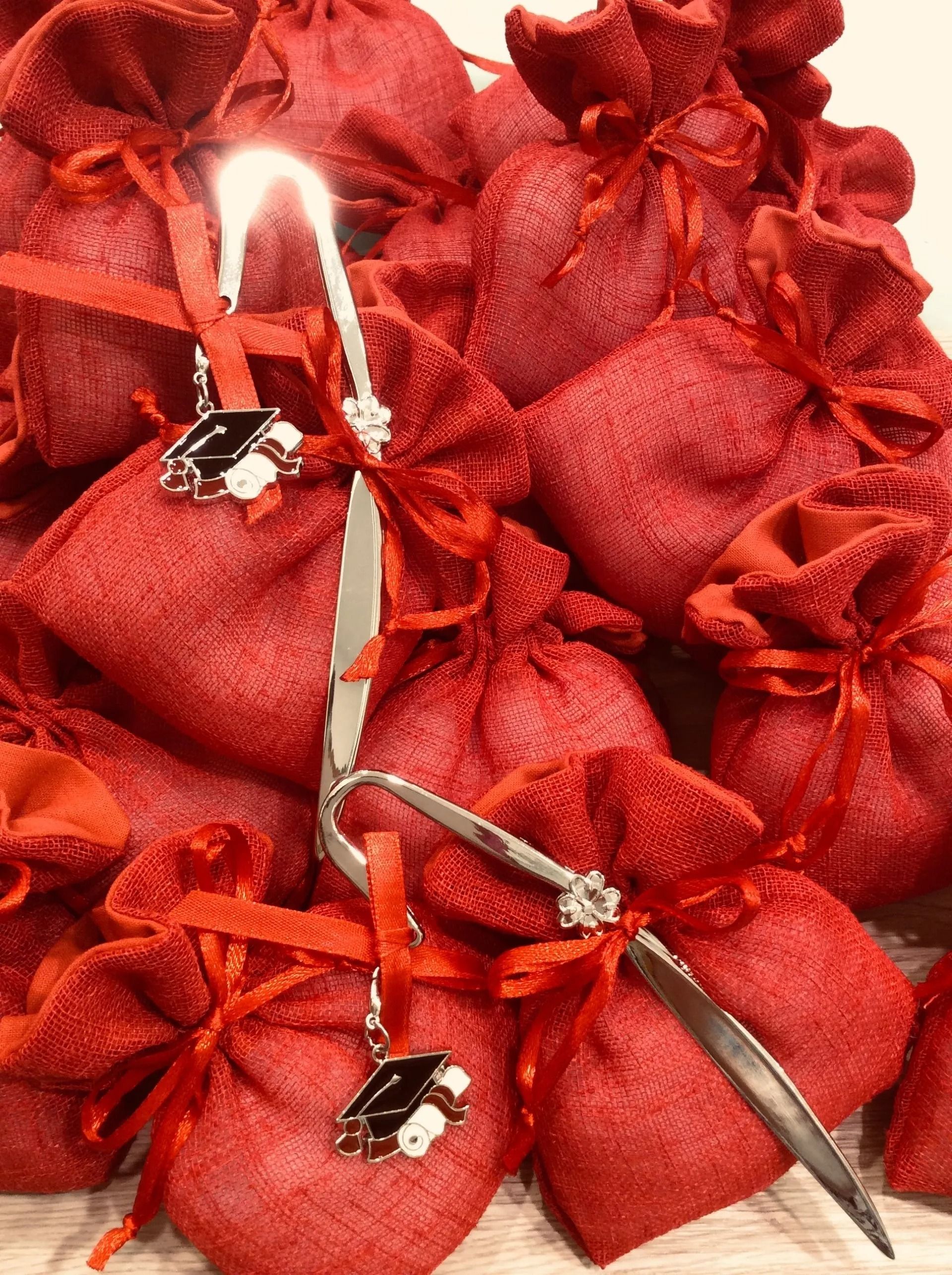 Composizione floreale rossa con steli grigio-argento e piccoli dettagli decorativi in bianco e nero.