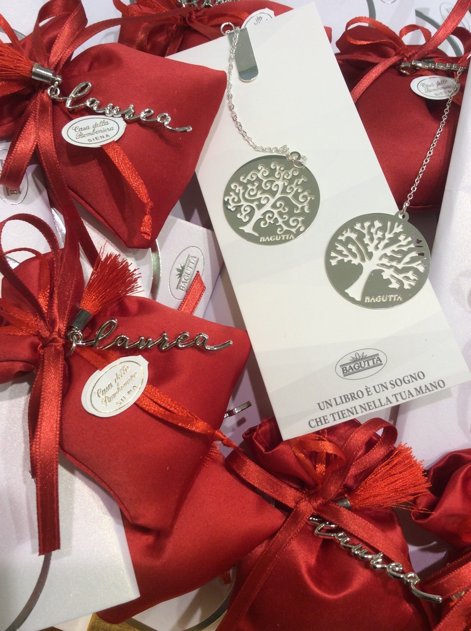 Sacchetti regalo rossi con etichette bianche e fiocchi di nastro festivi impilati uno sull'altro