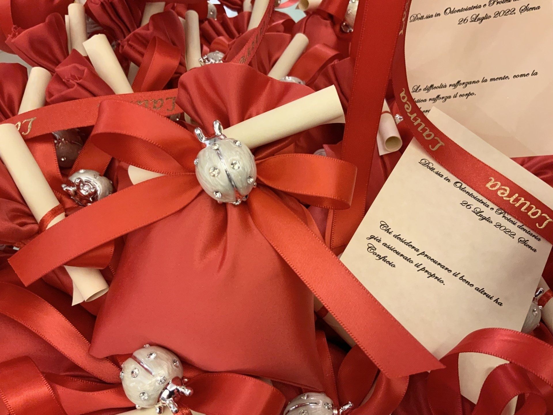 Fiocchi di nastro rosso legati attorno agli articoli arrotolati ed etichette regalo con ornamenti argentati