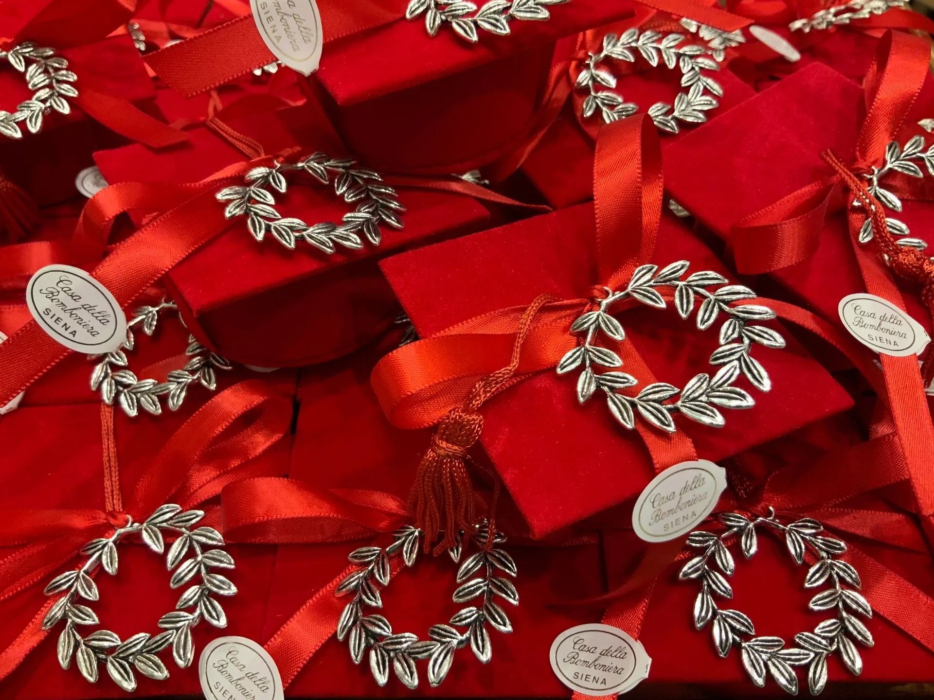 Scatole regalo rosse con decorazioni a ghirlanda argentate e nastri impilate una sull'altra