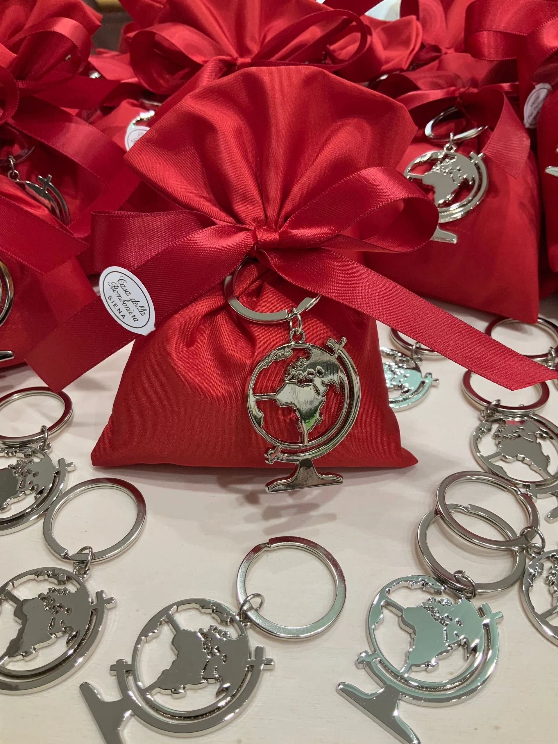 Sacchetti regalo rossi con portachiavi e anelli d'argento sparsi tutt'intorno