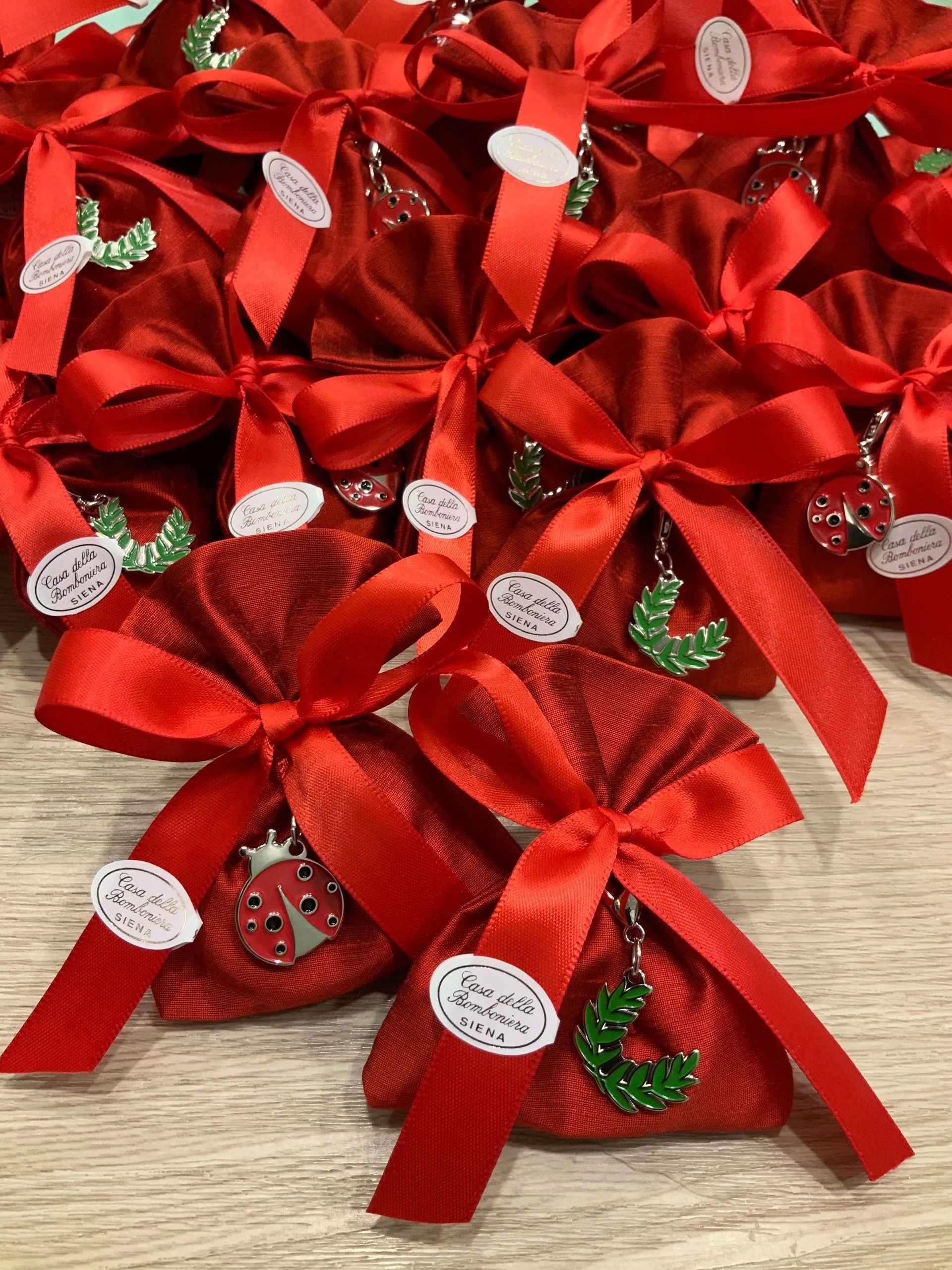 Fiocchi regalo rossi e decorazioni natalizie scintillanti disposti su un tavolo.