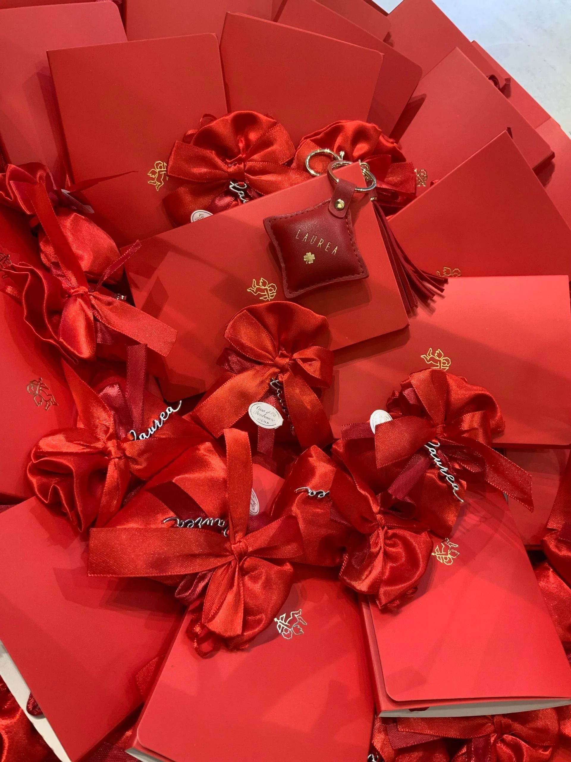 Scatola regalo rossa piena di fiocchi rossi lucidi e petali di carta rossa piegati