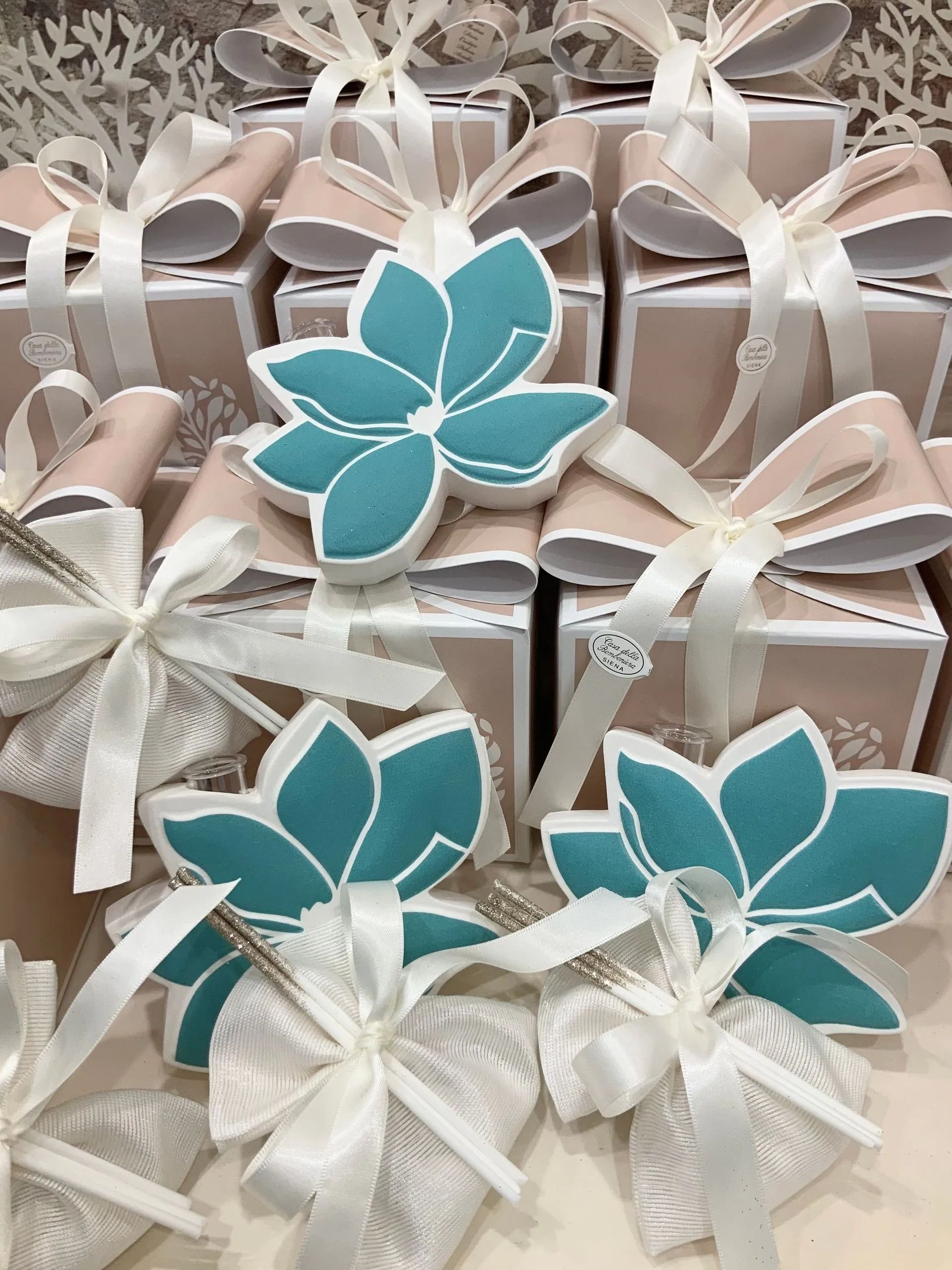 Scatole regalo incartate con nastri bianchi e decorazioni floreali blu