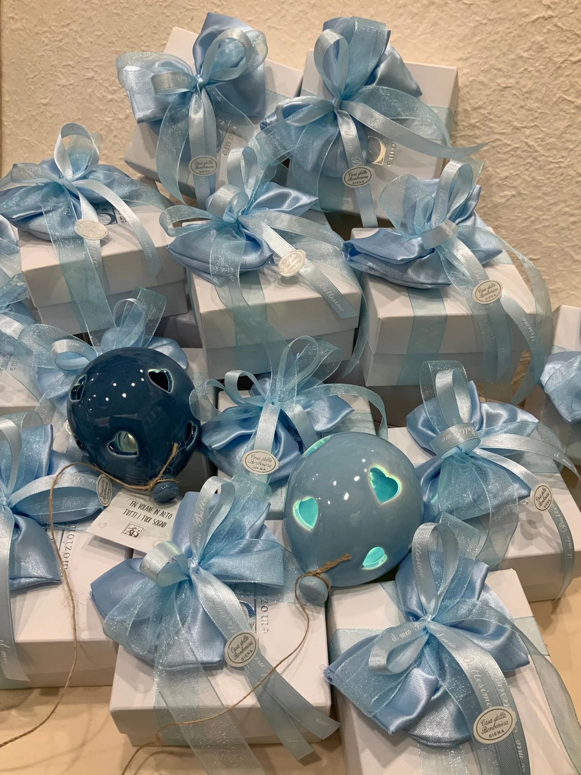 Scatole regalo blu impilate, avvolte con fiocchi trasparenti e decorate con faccine rotonde di personaggi.