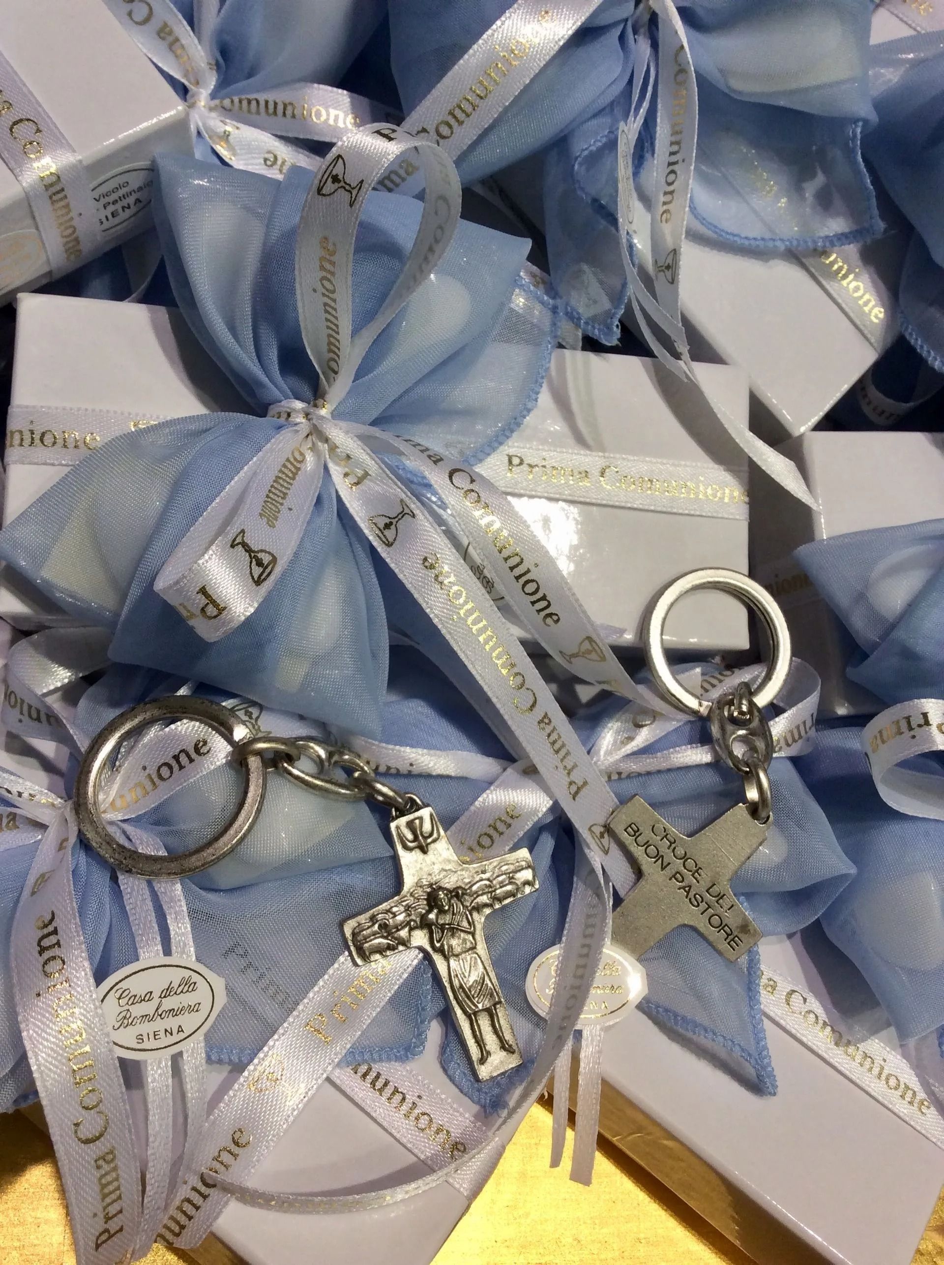 Scatole regalo avvolte in un nastro blu con portachiavi e ciondoli decorativi argentati