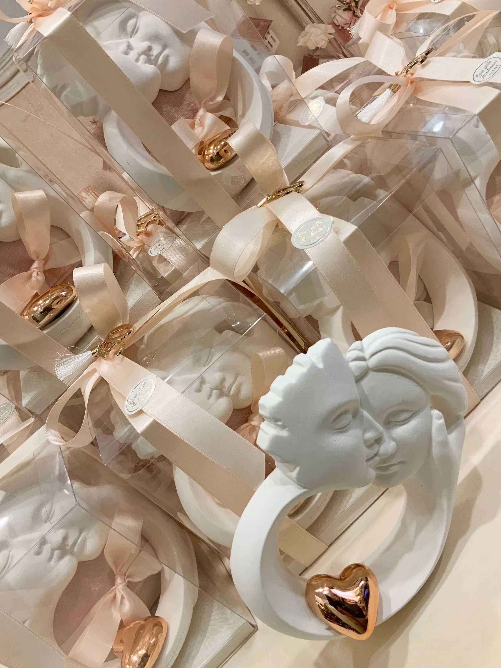 Ciondolo a forma di busto bianco con cuore in oro rosa su un letto di nastri di raso beige