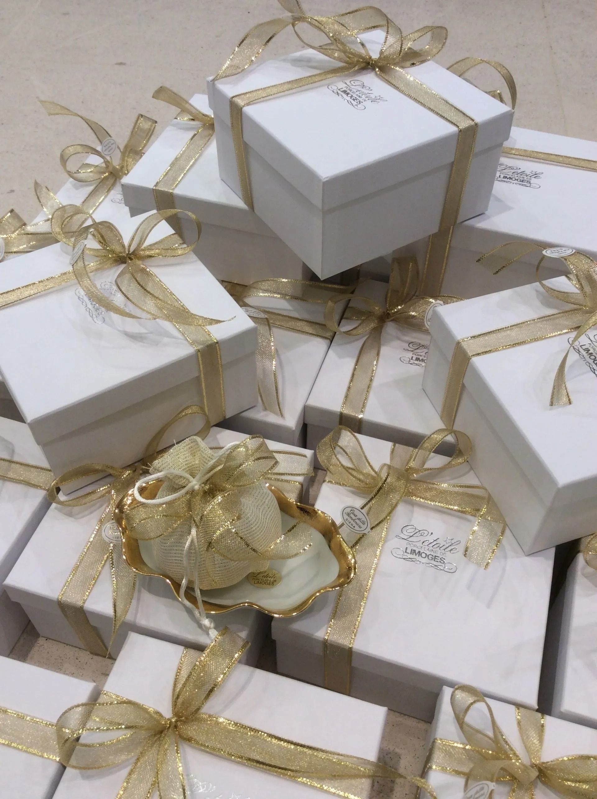 Scatole regalo bianche impilate con fiocchi di nastro dorato
