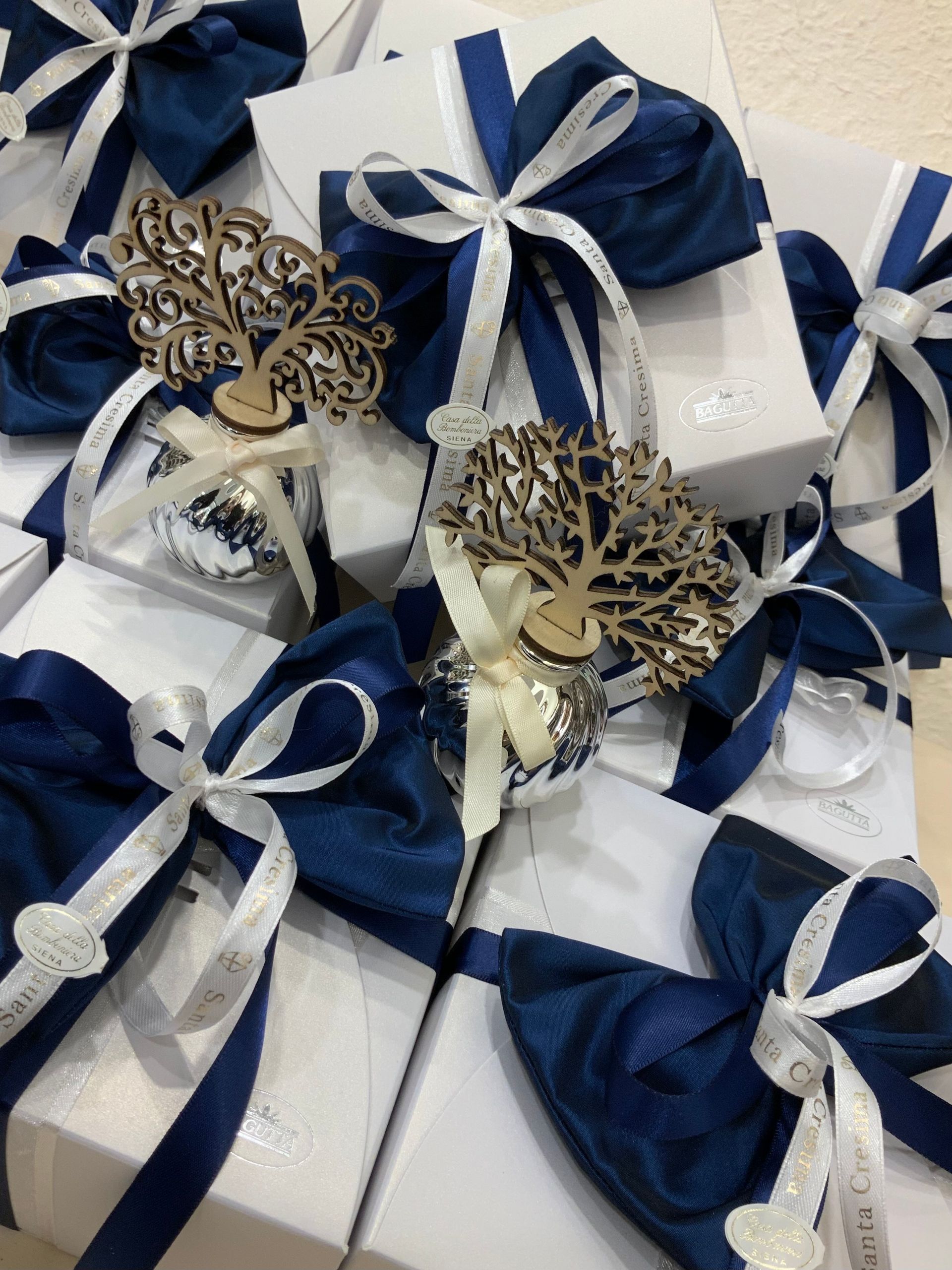 Scatole regalo blu e bianche con nastri e decorazioni a forma di farfalla.