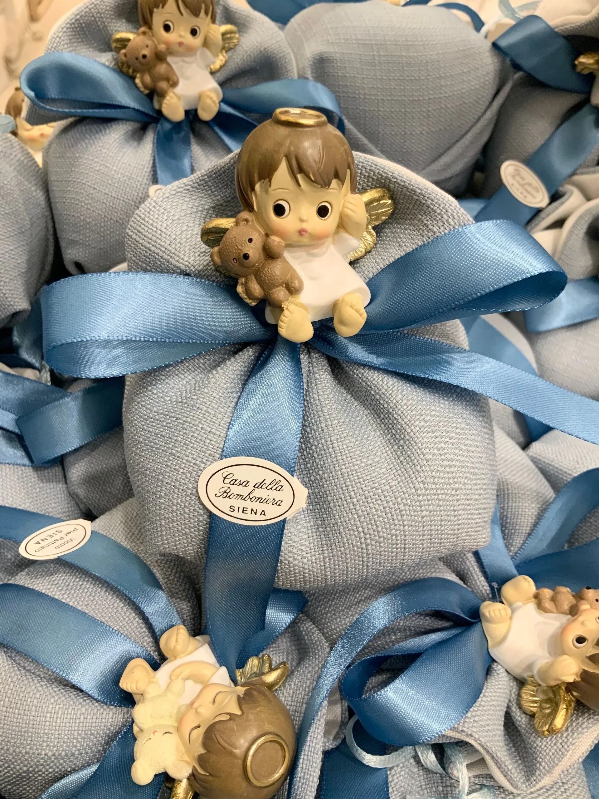 Sacchetti regalo blu con statuette dorate e orsetti di peluche legati con nastri di raso