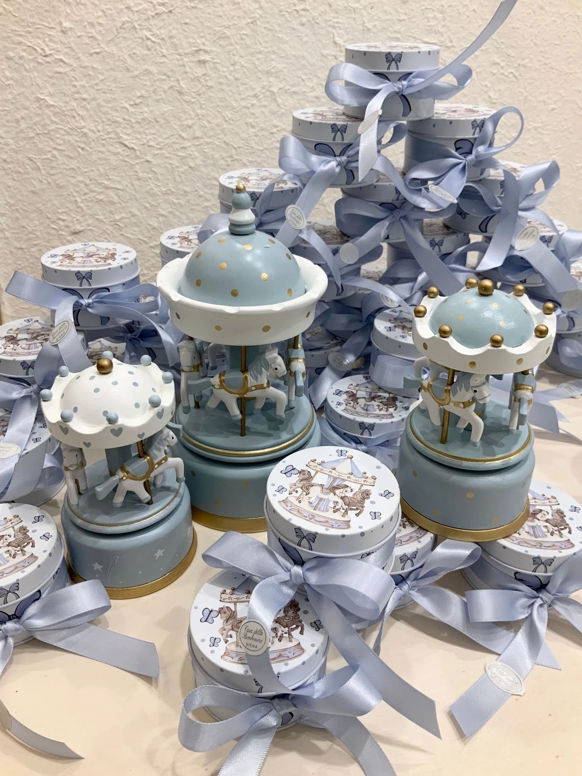 Lanterna e vasi decorativi color azzurro pastello con nastri, disposti su un tavolo.