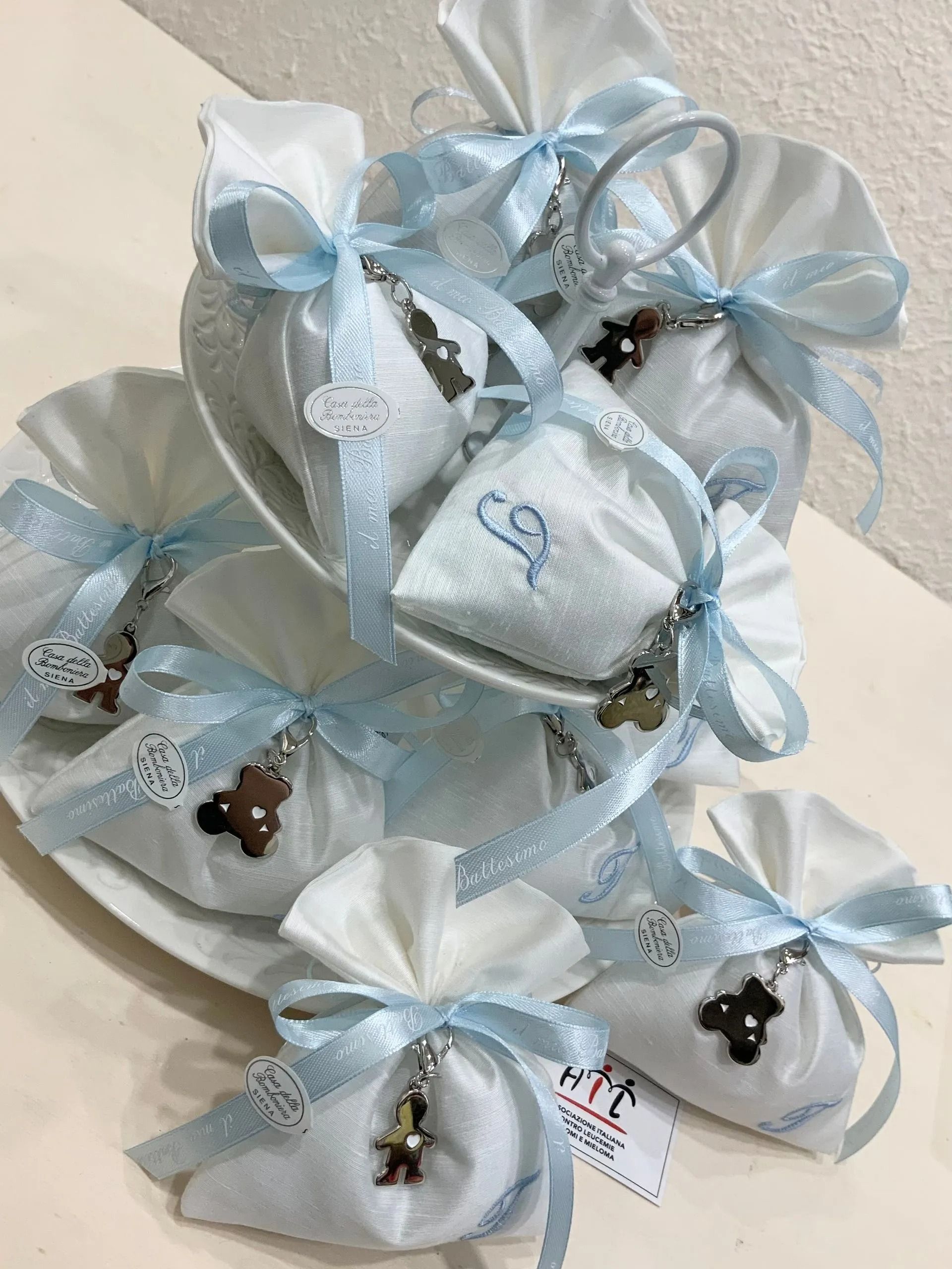 Scatole regalo bianche e azzurre con nastri impilate su un piatto