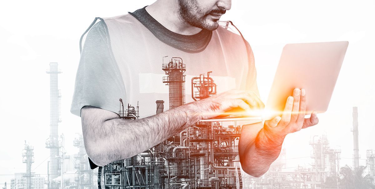 Man working on a laptop with a glowing digital city and industrial overlay in the background