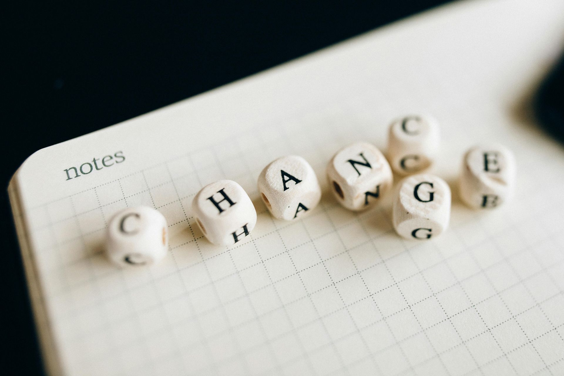 Wooden letter blocks on a grid notebook spelling the word
