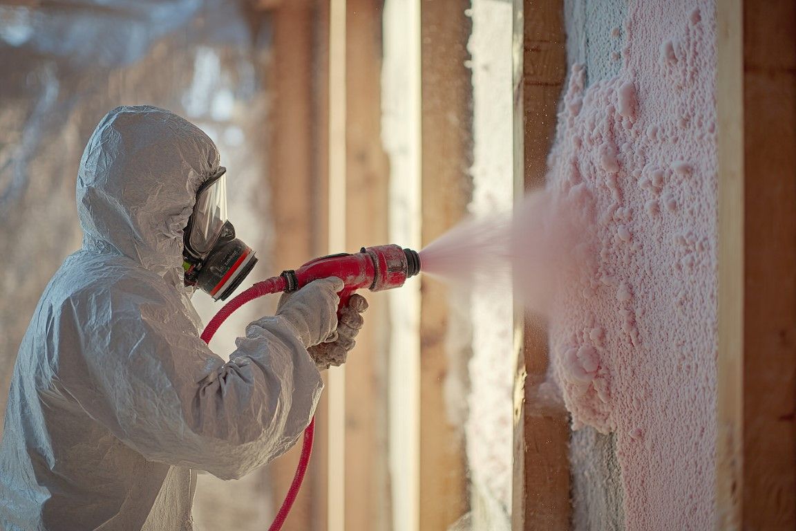 Spray foam insulation being applied inside residential wall cavity