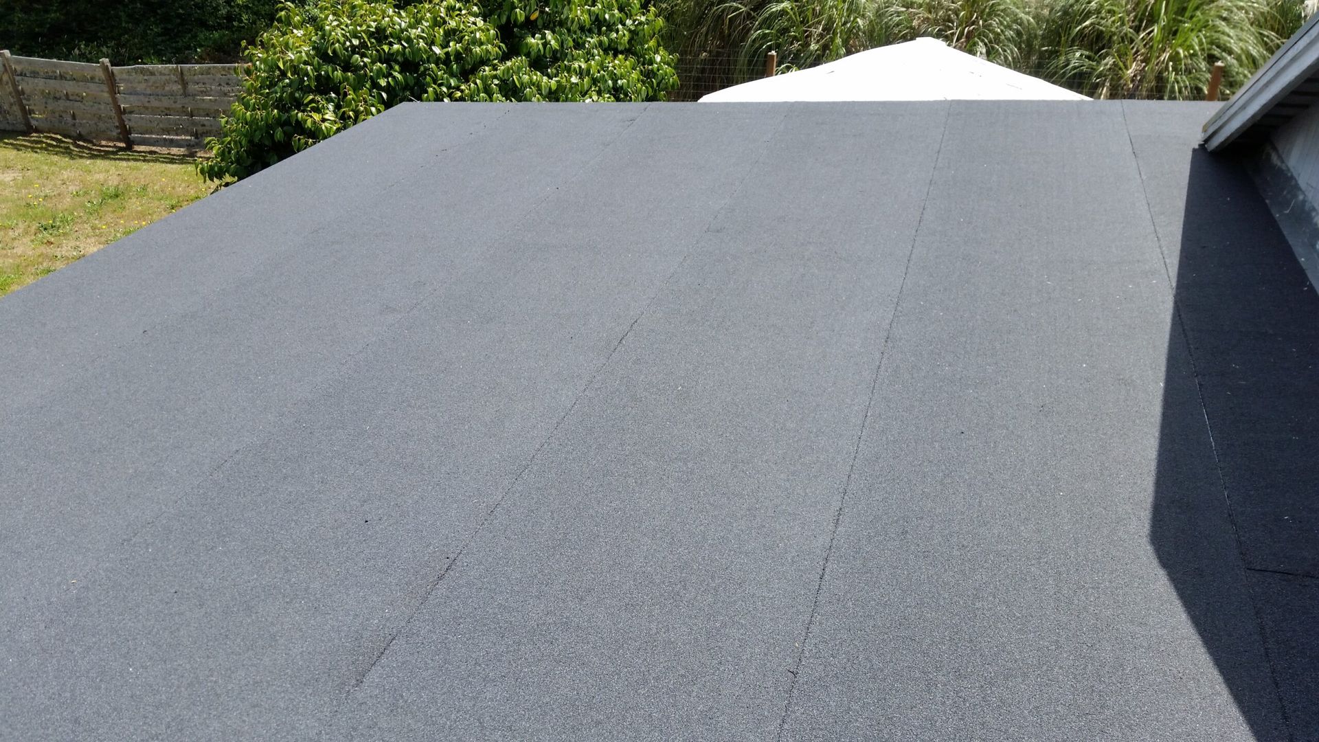 Gray gravel roof with a white patio umbrella peeking over the ridge, seen from above.