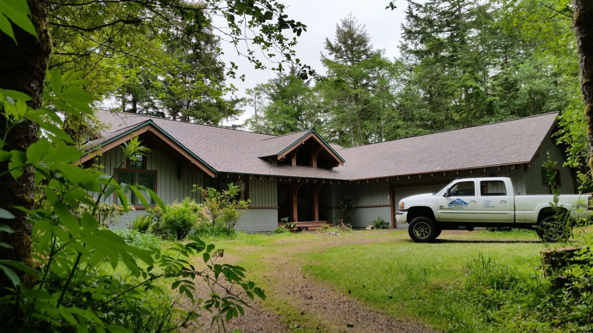 Rustic cabin in a wooded clearing with a white pickup truck parked out front.