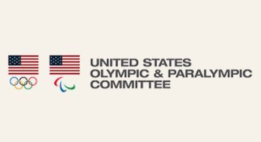 United States Olympic & Paralympic Committee logo with two U.S. flags and Olympic rings on a light background