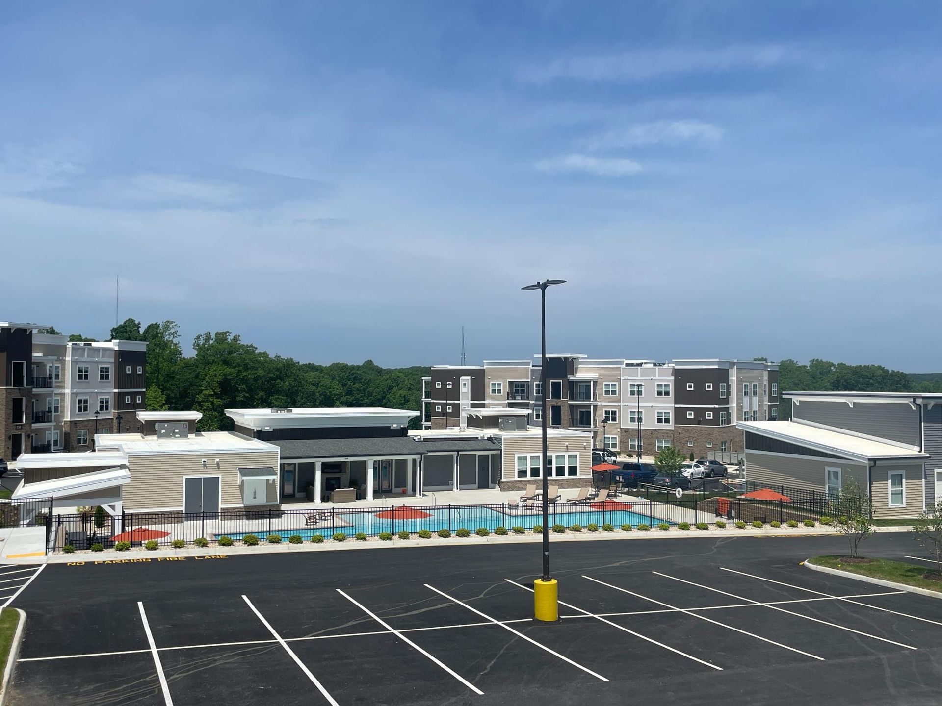 A parking lot in front of a building with a pool
