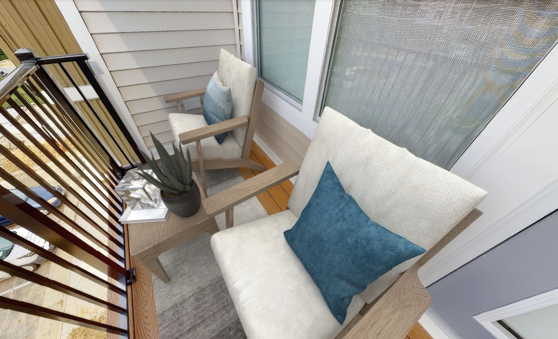 An aerial view of a balcony with a chair and table.