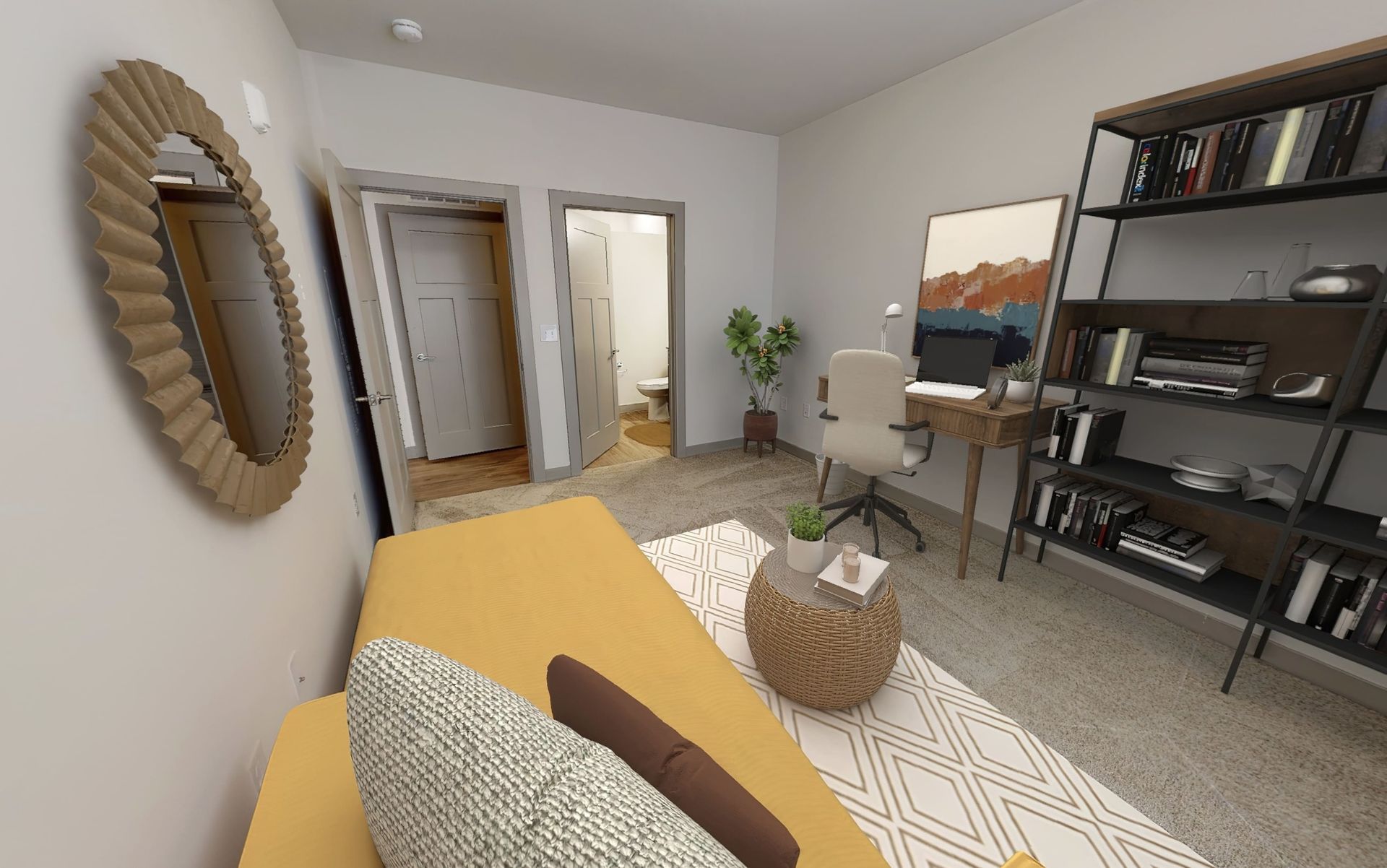 A living room with a yellow couch , a desk , and a mirror.