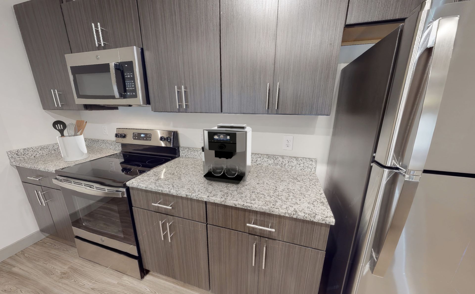 A kitchen with stainless steel appliances and granite counter tops.