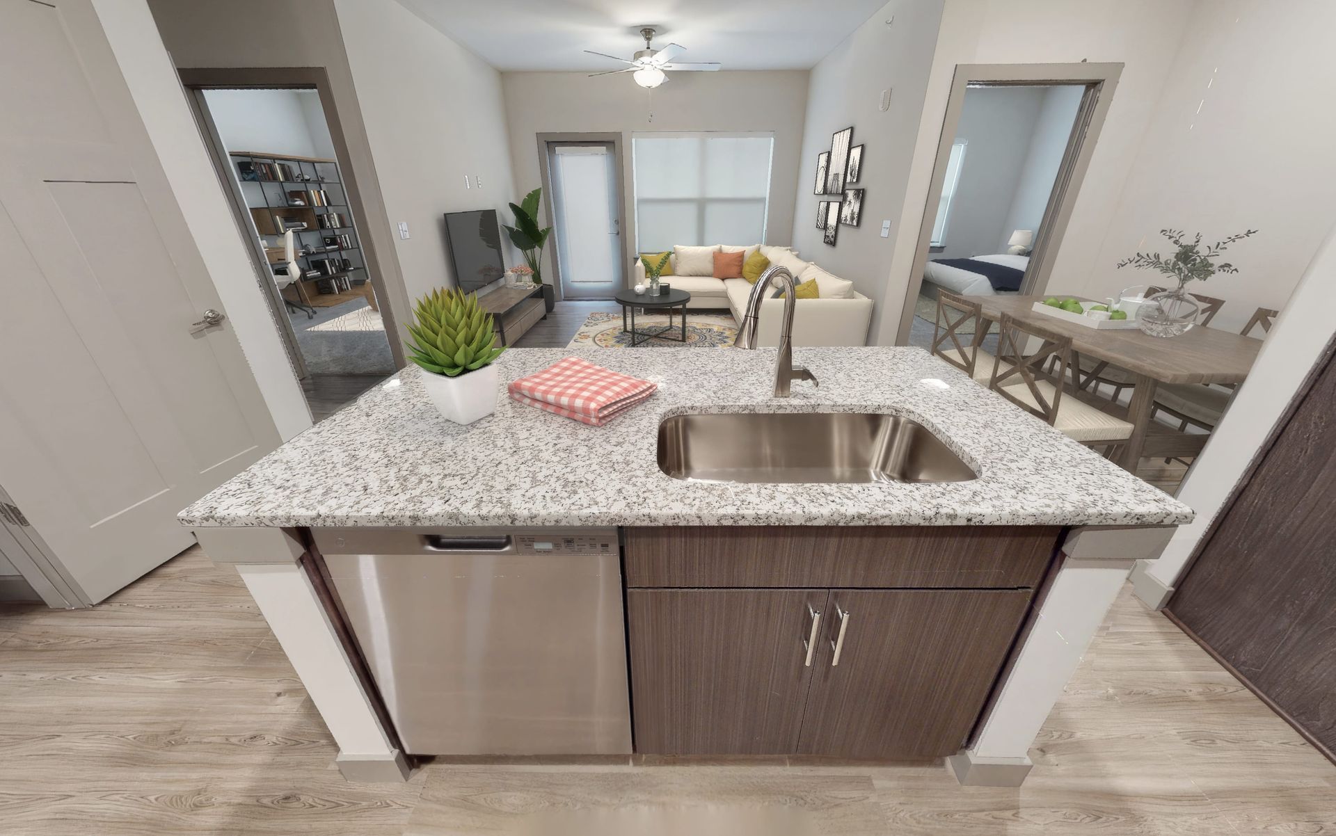 A kitchen with a sink , dishwasher , and granite counter top.