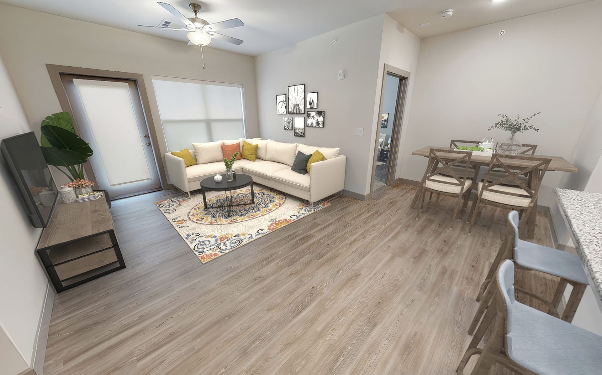 A living room with a couch , table , chairs and a ceiling fan.
