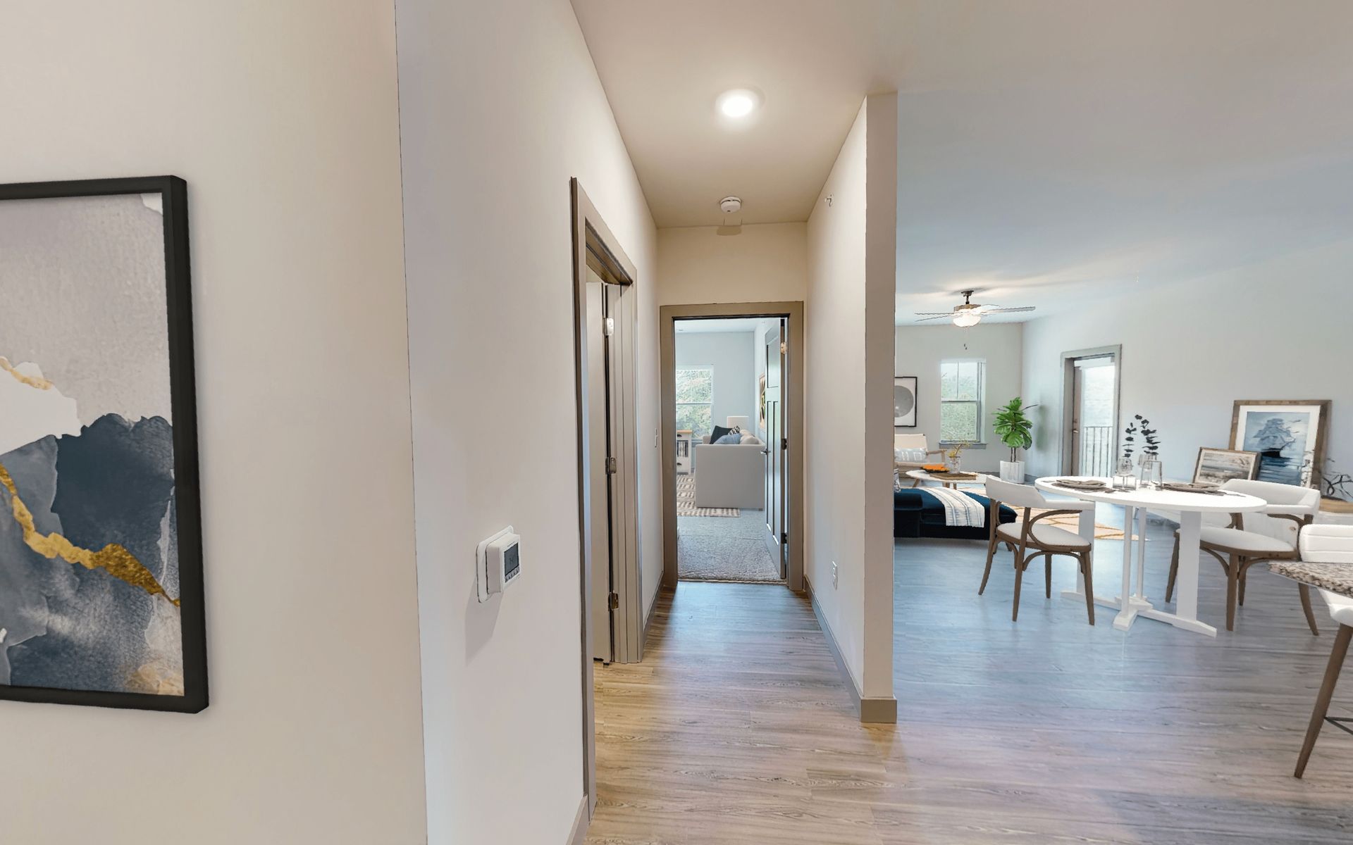 A hallway leading to a living room and dining room in a house.