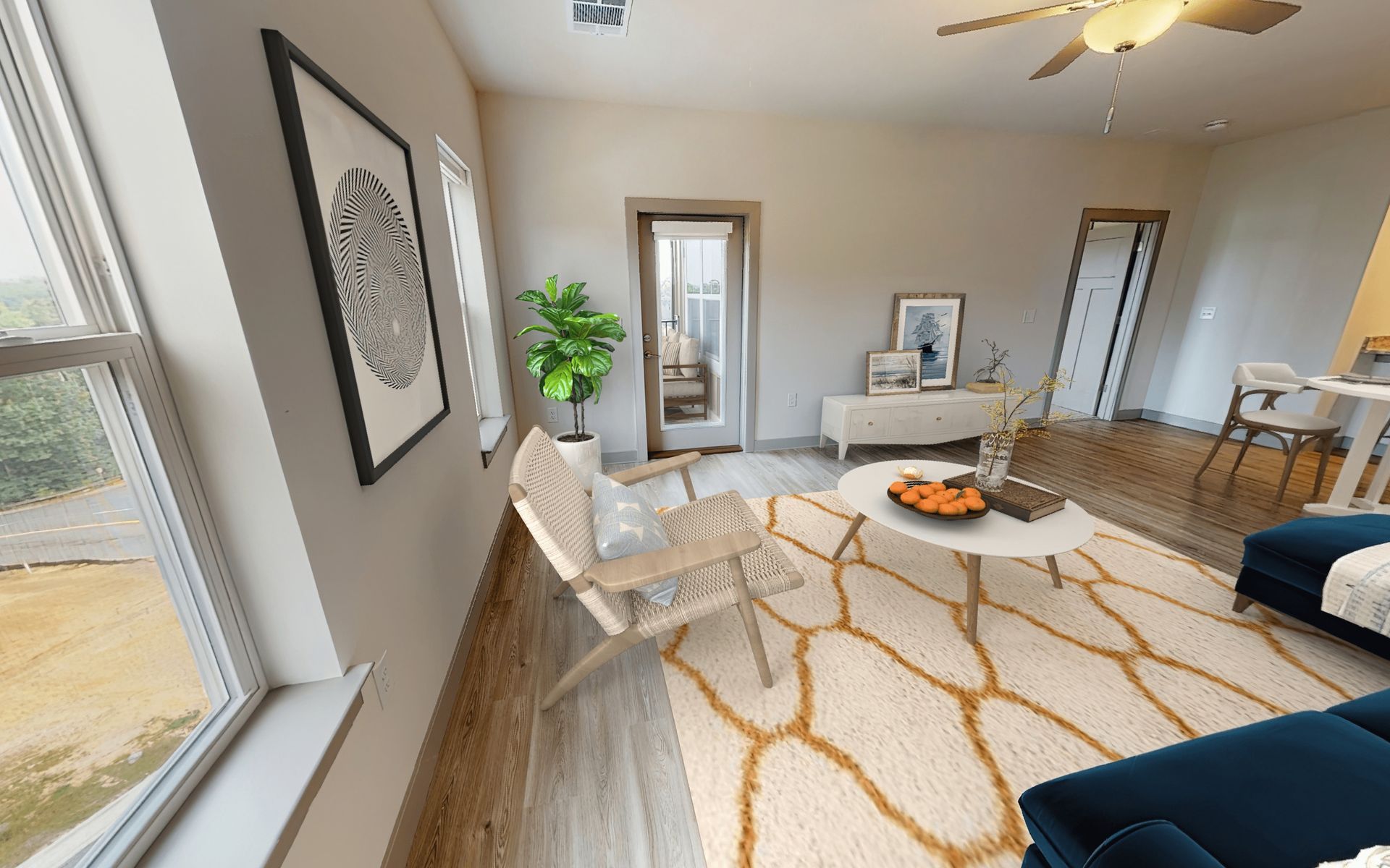 A living room with a couch , chair , coffee table and ceiling fan.