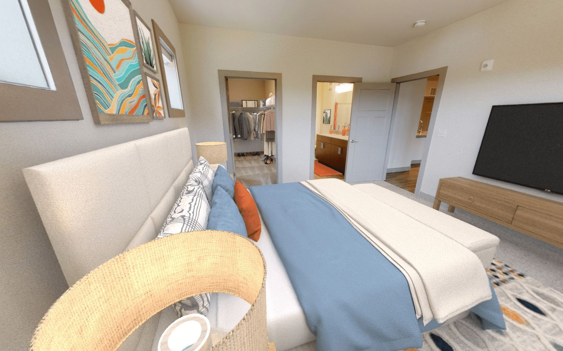 A bedroom with a bed , lamp , television and walk in closet.
