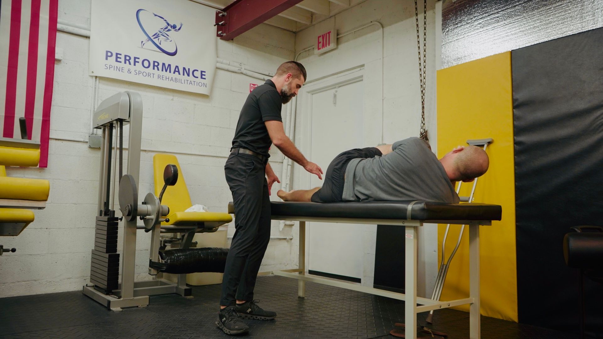 Therapist adjusting a person's back while lying on a treatment table.