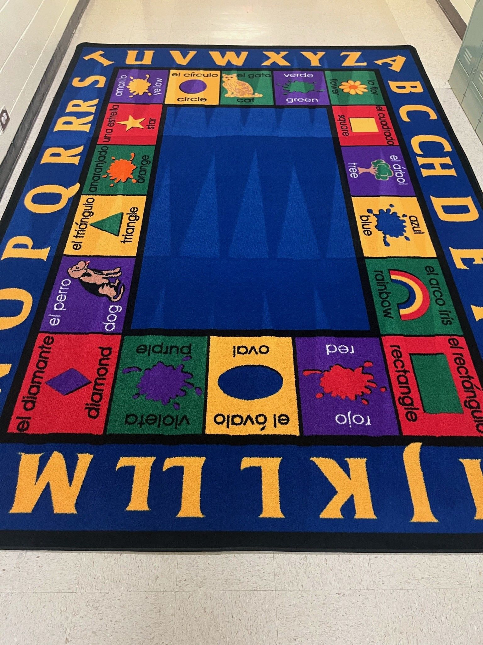 Colorful alphabet classroom rug with letters around the border and shapes in the center