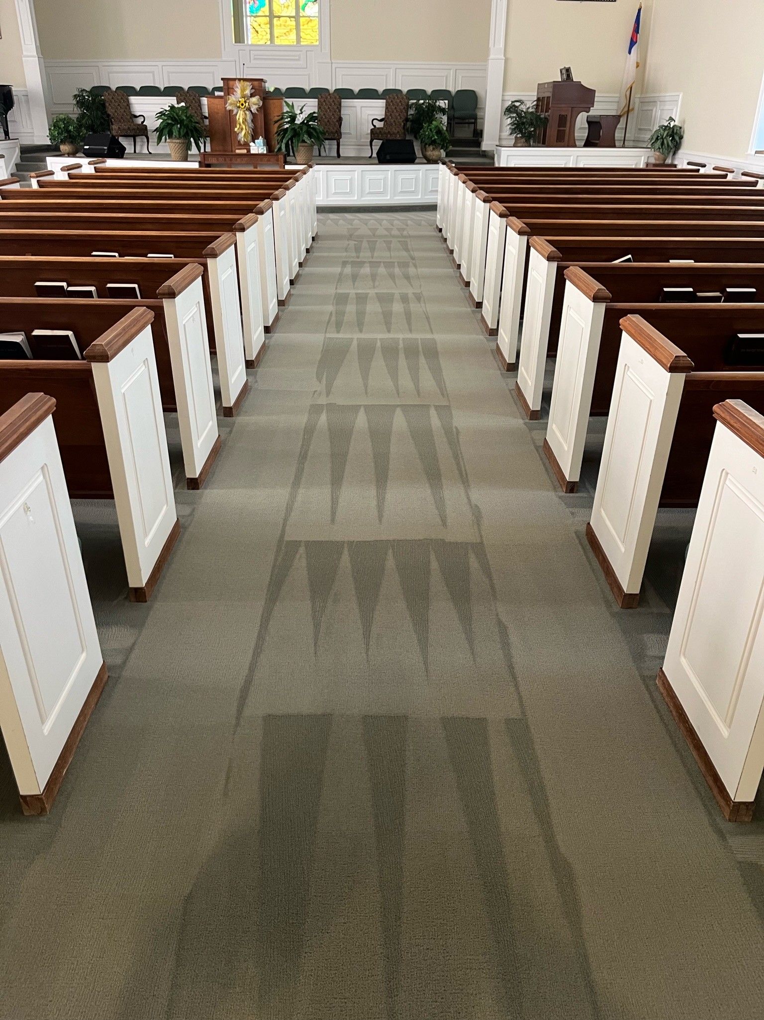 Empty church aisle with wooden pews on both sides and an altar at the front