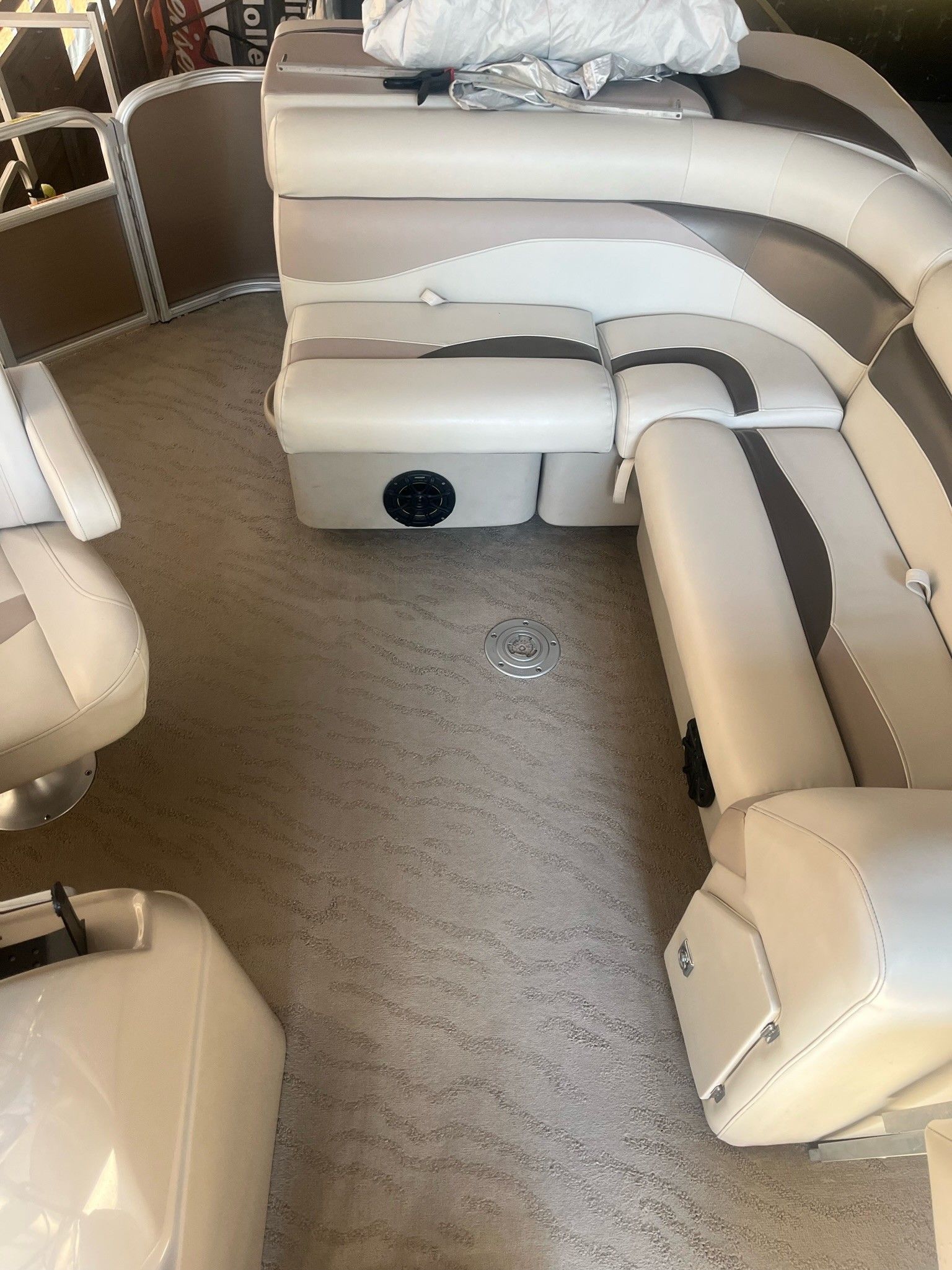 Cream-colored boat cabin with U-shaped bench seating and carpeted floor, viewed from the center aisle.