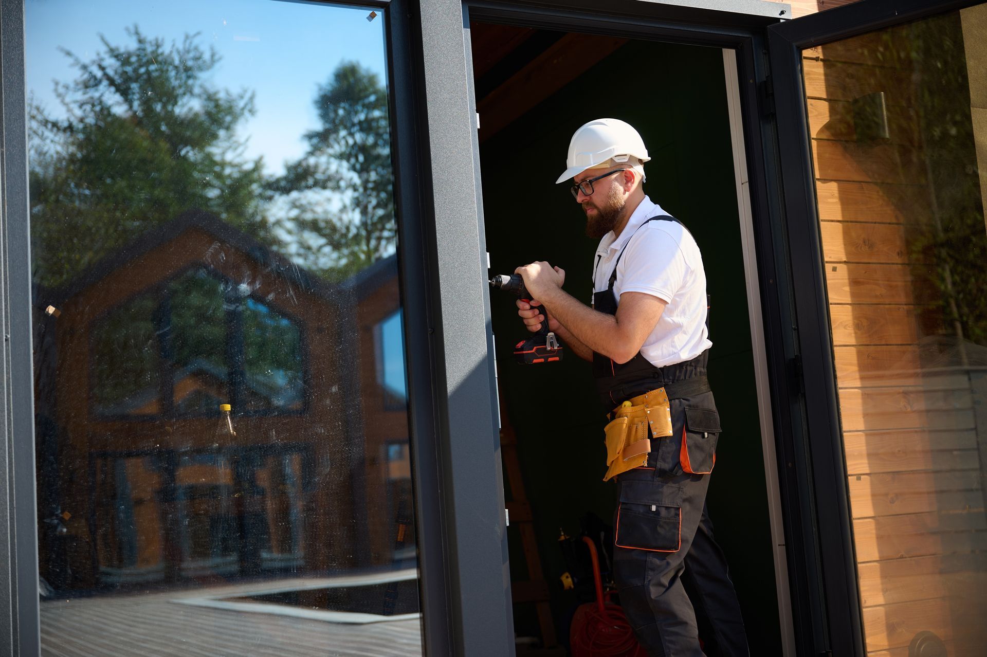 Construction worker using a drill on a doorframe